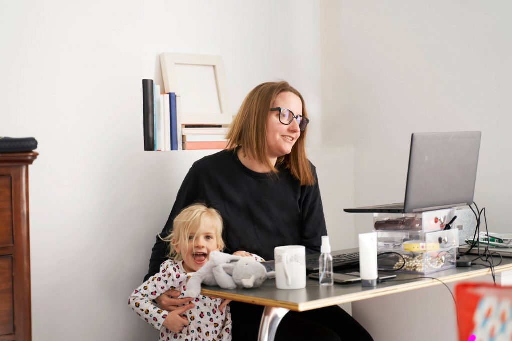 Kobieta z dzieckiem podczas pracy zdalnej