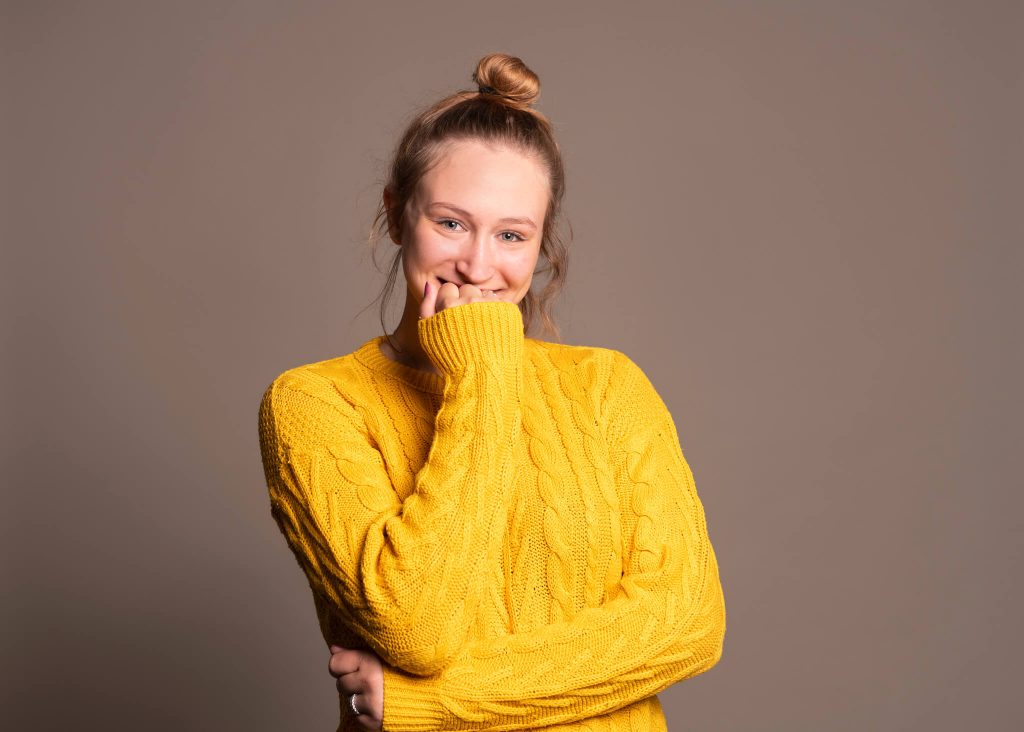 Nieśmiała kobieta w żółtym swetrze