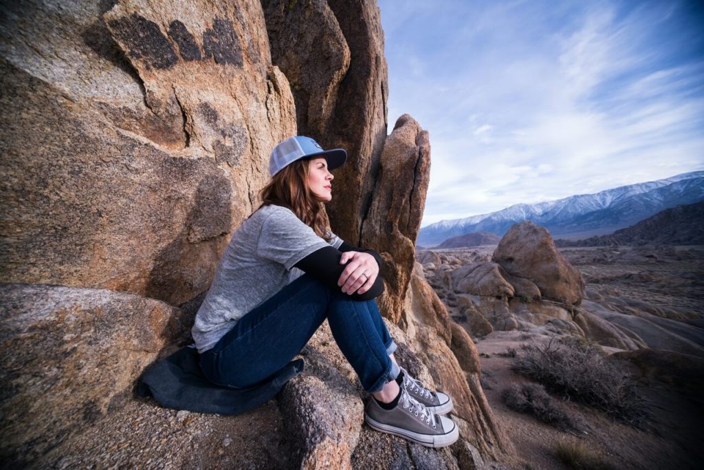 Kobieta siedząca na stromych skałach